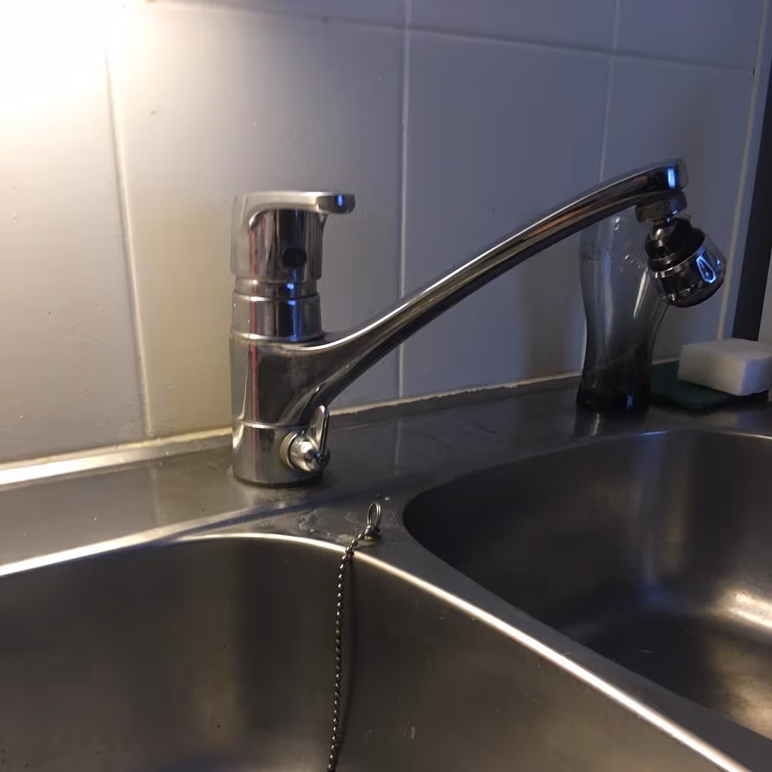Krominen keittiöhana suihkupäällä on asennettu ruostumattomaan teräkseen tiskialtaaseen.